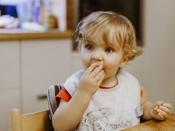Cute baby eating food at home