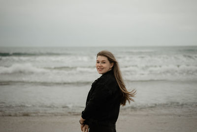 Portrait of young woman standing on beach