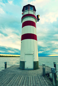 Romantic evening walk on wooden mole to lighthouse at lake neusiedl  sunset, burgenland, austria