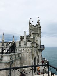 View of building by sea against sky