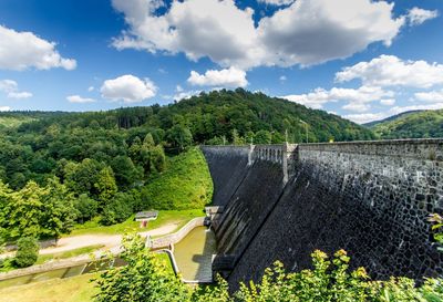 Dam by mountains against sky