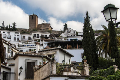 Buildings in city against cloudy sky