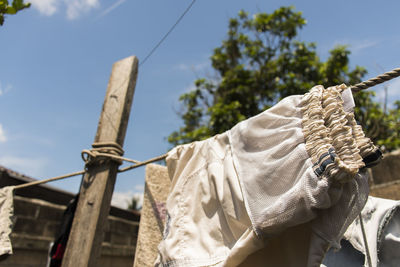 Low angle view of clothes hanging on rope against sky