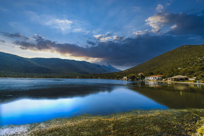 Scenic view of lake by mountains against sky