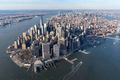 High angle view of modern buildings by sea against sky