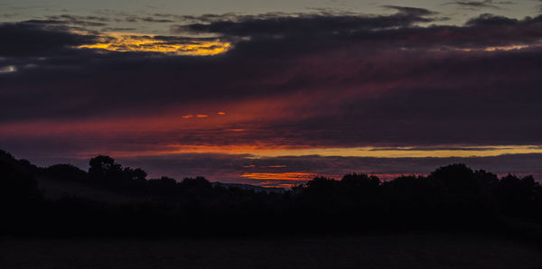 Scenic view of dramatic sky at sunset