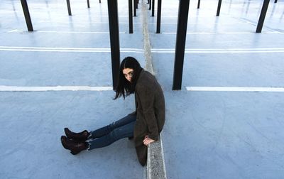 High angle portrait of woman standing against wall