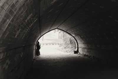 Rear view of silhouette man walking in tunnel