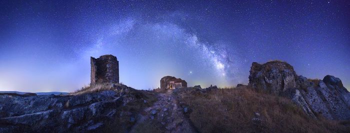 Low angle view of rock formation against sky at night