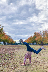 Full length of woman walking on field against sky