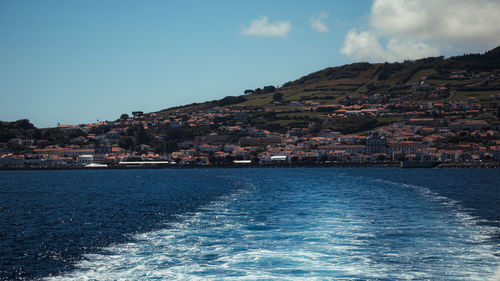 Scenic view of sea by town against sky