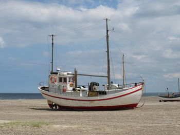 Sailboats moored on sea against sky