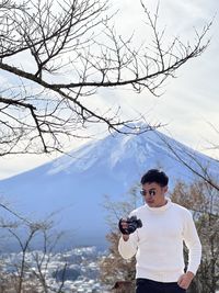 Rear view of man standing on snow covered landscape fuji mountain 