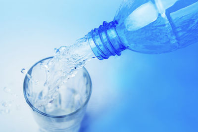 Close-up of glass bottle against blue background