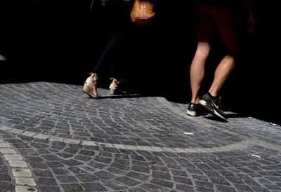 Low section of people walking on street at night