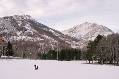 Rear view of man walking on snow covered mountain