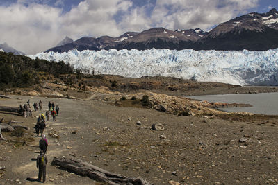 People on snowcapped mountain against sky