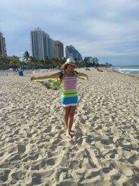 Full length of woman walking at beach in city