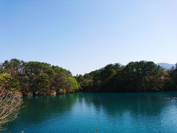 Scenic view of lake against clear blue sky