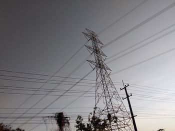 Low angle view of electricity pylon against clear sky