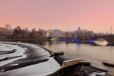 Bridge over river at sunset