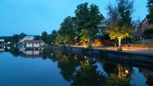 Reflection of trees and buildings in lake at night