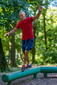 Full length of man with arms raised in park