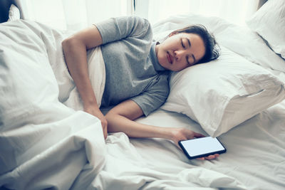 Midsection of man sleeping on bed