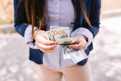 Midsection of woman holding camera