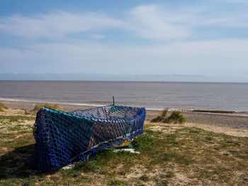 Fishing boat covered with net on sandy beach big sky 
