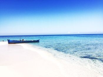 Scenic view of beach against clear blue sky