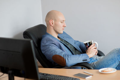 Businessman having coffee at desk in office