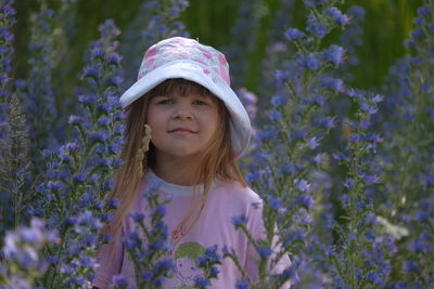 Portrait of smiling girl standing amidst purple flowers