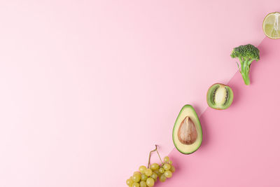 Directly above shot of fruits on pink background