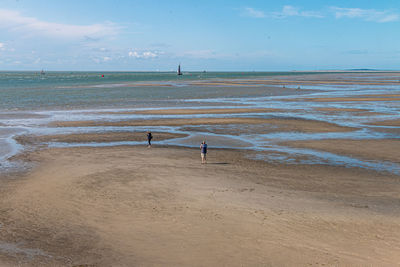 People on beach against sky