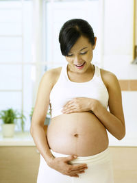Side view of pregnant woman at home