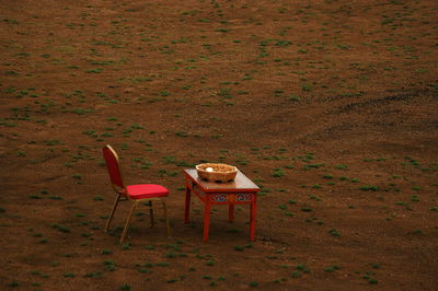 High angle view of chairs and table on field