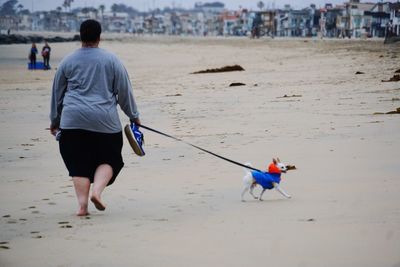 Rear view of men walking on beach