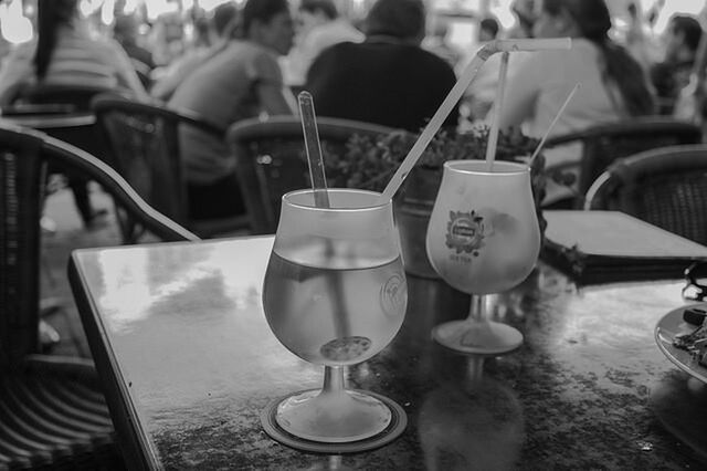 indoors, table, men, incidental people, food and drink, restaurant, drink, focus on foreground, person, lifestyles, chair, sitting, close-up, refreshment, cafe, leisure activity, day, glass - material, reflection
