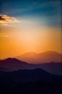 Scenic view of silhouette mountains against sky at sunset