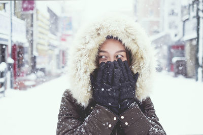 Portrait of young woman in snow during winter