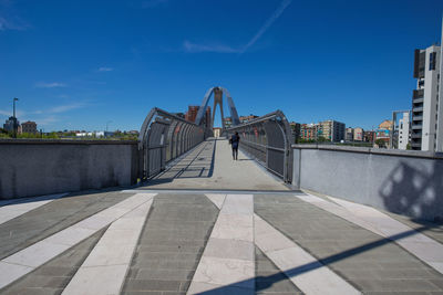 View of bridge in city against blue sky