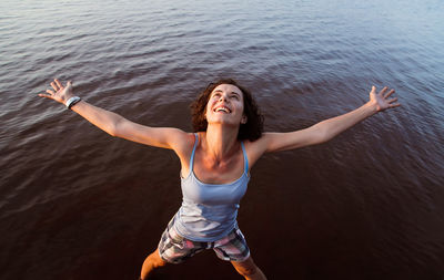 Young woman with arms outstretched in water