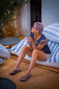 Full length of woman holding drink glass