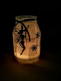 Close-up of illuminated lamp against black background