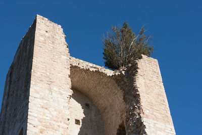 Low angle view of old building against blue sky