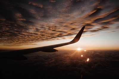 Airplane flying in sky during sunset