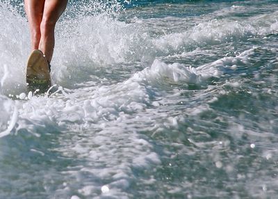 Low section of person waterskiing on sea