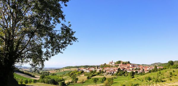 Scenic view of townscape against clear blue sky