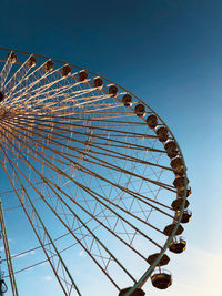 Low angle view of ferris wheel against blue sky